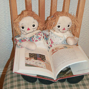 Raggedy Ann & Andy holding book